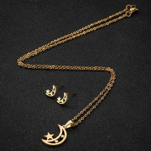 Parure de bijoux dorée avec pendentifs lune et étoile sur un fond sombre texturé