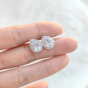 Close-up of silver pear-shaped halo stud earrings with brilliant clear zircon stones