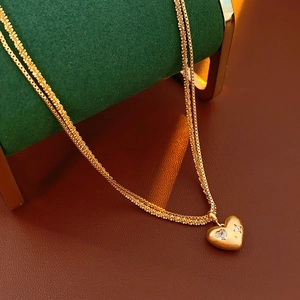 Détail d'un collier pendentif double cœur avec zircons blancs sur support à bijoux