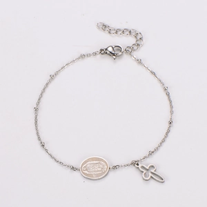 Detail view of silver stainless steel bracelet featuring Virgin Mary medal and cross pendants