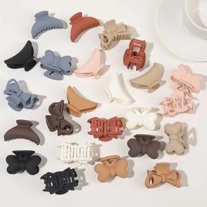 Detailed flat lay of matte claw clips in bow and geometric styles in Morandi colors