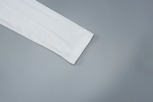 Détail du poignet de manche en coton blanc avec couture professionnelle à double aiguille