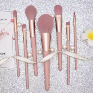 Detail of 7pcs pink makeup brush set with rose gold ferrules on glitter background