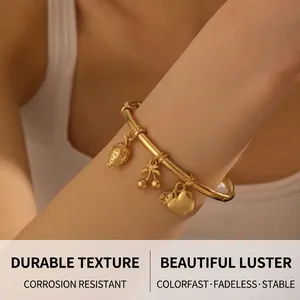 Gold-plated bangle featuring detailed strawberry, cherry, and apple charms on a wrist