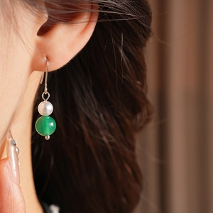 Primo piano di orecchini vintage in argento con perla bianca e perla di agata verde