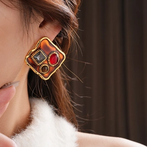 Gros plan de boucles d'oreilles vintage dorées avec œil de tigre sur modèle féminin