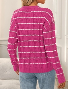 Detail of fuchsia cable knit cardigan featuring elegant white wavy stripe patterns