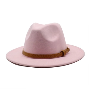 Close-up of pink wool fedora hat with a textured brown leather decorative band