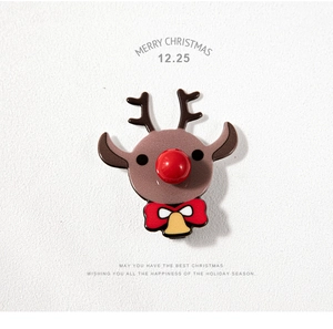 Détail d'une mignonne broche de Noël renne avec finition brillante et nez rouge vif
