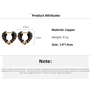 Vue détaillée des boucles d'oreilles cœur en or 18k avec garniture en cuir noir