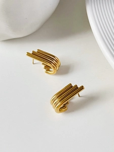 Detailed view of 18K gold wing earrings with minimalist parallel curved metal design