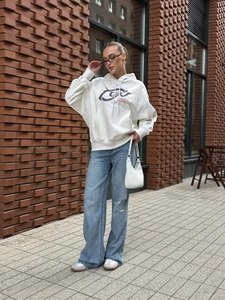 Street style white hoodie detail with Focus on Excellence print in outdoor scene