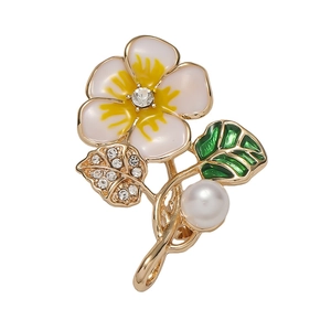 Floral brooch with white petals, yellow center, green enamel leaf, and elegant pearl