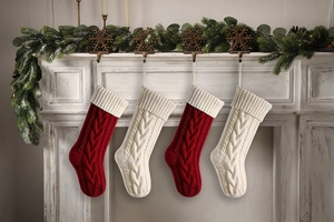 Close-up of four red and cream knitted Christmas stockings hanging on a fireplace mantel