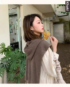 Close-up of khaki hooded knit shawl vest with vertical ribbing and pleated sleeve dress
