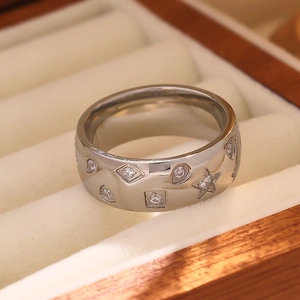 Macro shot of silver geometric engraved ring with star patterns in a wooden jewelry box