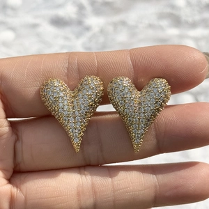 Elegant gold heart stud earrings with sparkling pave-set crystals shown in hand