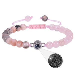 Detail der Projektionsperle mit 100 Sprachen Ich liebe dich auf dem rosa Steinarmband