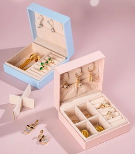 Detail of portable pink and blue jewelry boxes showing interior ring slots and hooks