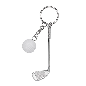 Miniature golf club and white ball keychain in polished silver metal on white background