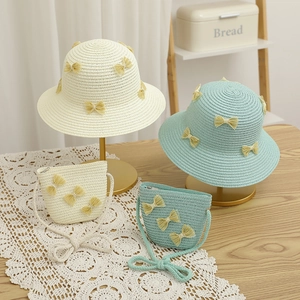 Detailed weave of child's straw hat and matching bag with elegant yellow mesh bow