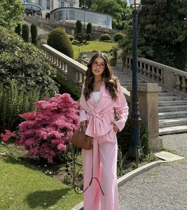 Outdoor shot of women pink drawstring long sleeve shirt and wide leg pants set with white crop top