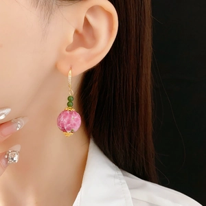 Detail von floralem Glasperlenohrring mit rosa Marmorstruktur und goldenem Strasshaken