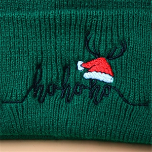 Deep green knit Christmas beanie featuring festive elk antler and ho ho ho embroidery