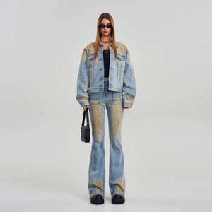 Dettaglio di un completo in denim lavato vintage con giacca cropped e jeans svasati
