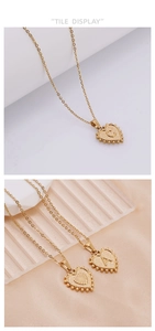 Detail of gold heart pendant necklace with beaded edges and engraved initial alphabet