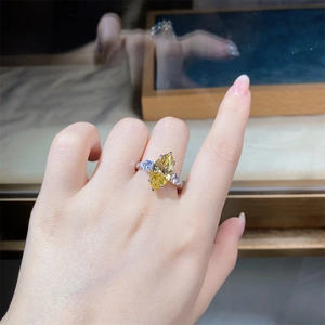 Close-up of yellow marquise-cut center stone and pear-shaped side diamonds on silver ring