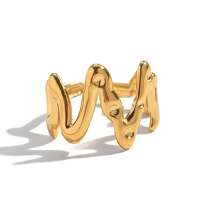 Vue macro de la bague vague dorée avec détails en relief ronds et texture métallique