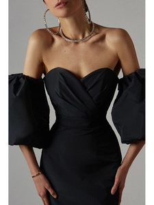 Detail of off-shoulder puff sleeves and heart-shaped crossover neckline on a black dress