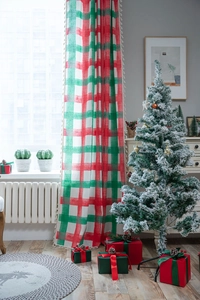 Detail of red and green plaid festive curtains with tassel edges in a Christmas room