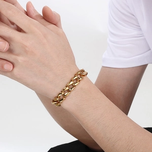 Detailed view of 11mm golden Cuban link steel bracelet on wrist with square clasp