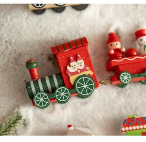 Close-up of wooden Christmas train with hand-painted Santa and snowman on snowy base