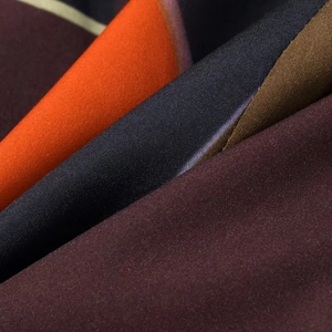 Close-up of printed long sleeve shirt fabric with orange and purple patterns and silk texture