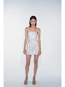 Vue de face d'une mini robe bustier à paillettes argentées portée par un mannequin