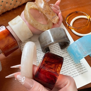 Detail of assorted resin bangles with tortoiseshell, amber and marble patterns