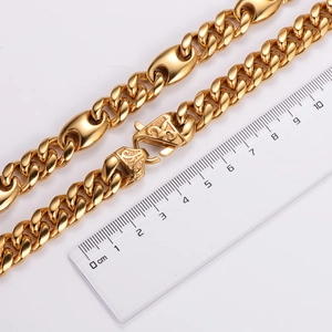 Macro view of gold stainless steel Cuban links with ruler showing chain thickness