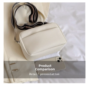 Detail presentation of off-white leather crossbody bag showing size compared to a phone