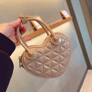 Detail of nude heart-shaped jelly bag with quilted texture and sturdy top handle