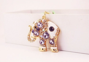 Close-up of golden elephant keychain featuring purple rhinestones and white enamel details