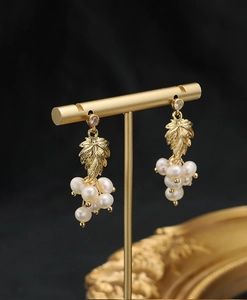 Detail of 18k gold plated grape leaf earring with white freshwater pearls and zircons