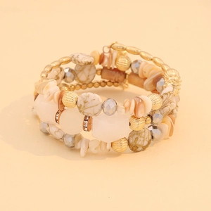 Close-up of bohemian layered wrap bracelet with gold beads and natural stone textures