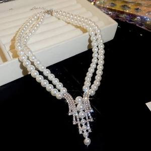 Detail of elegant double-layer pearl necklace with sparkling rhinestone pendant on display