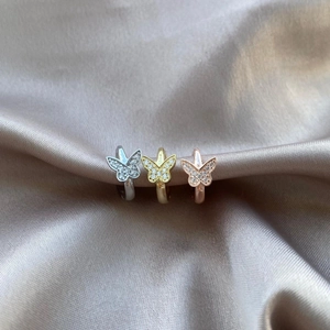 Three-color butterfly huggie earrings set with sparkling zircon on silk background