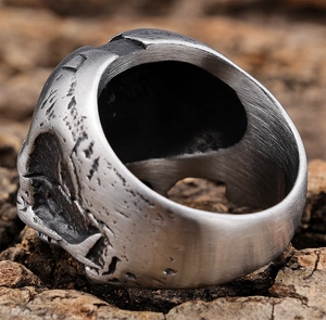 Close-up of vintage pilot skull ring with antique finish on rough wood texture
