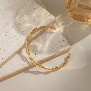 Minimalist twisted knot open cuff bracelet in 18K gold plated stainless steel on stone