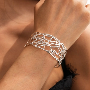 Close-up of silver hollow intertwined branch cuff bracelet on a female model's wrist